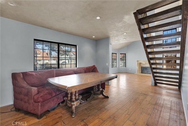 dining room featuring light hardwood / wood-style flooring, lofted ceiling, and a premium fireplace