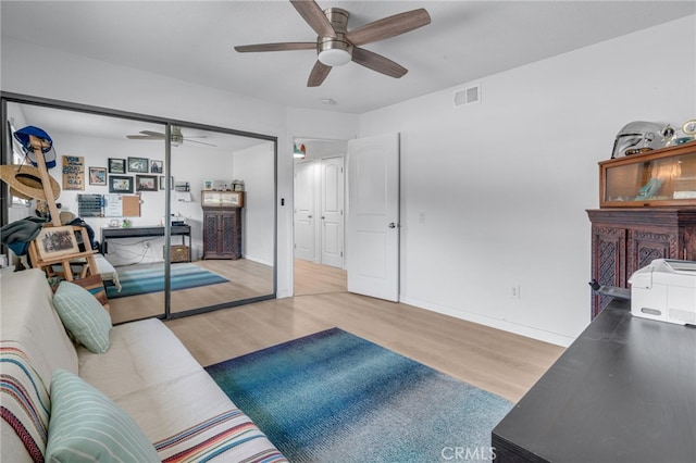 living room featuring light hardwood / wood-style floors and ceiling fan