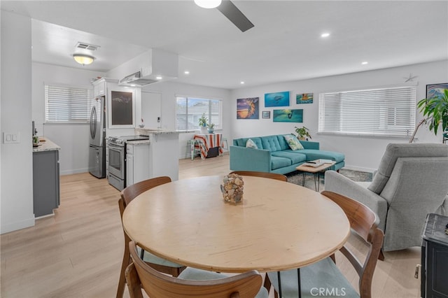 dining space with ceiling fan and light hardwood / wood-style floors