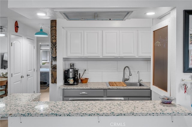 kitchen with gray cabinetry, sink, decorative backsplash, and white cabinets