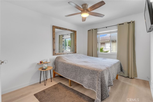 bedroom with multiple windows, light hardwood / wood-style flooring, and ceiling fan