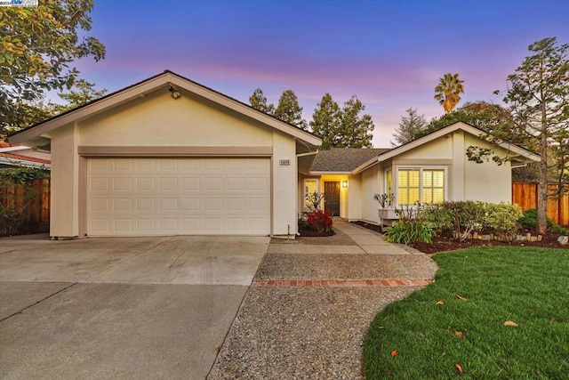 single story home featuring a yard and a garage