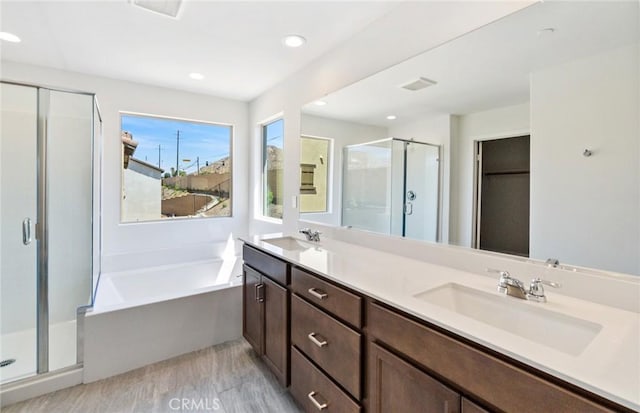 bathroom with vanity, independent shower and bath, and hardwood / wood-style floors