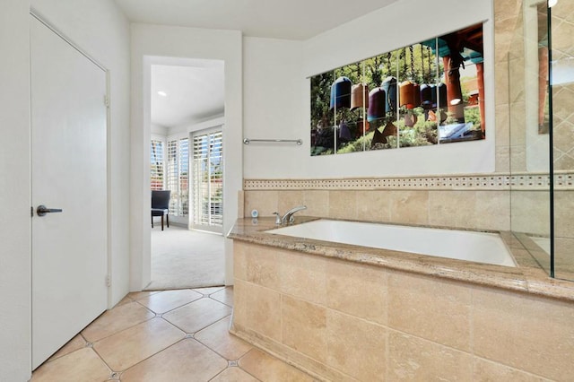 bathroom featuring tiled bath and tile patterned flooring