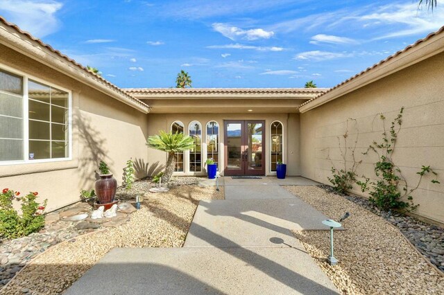 view of exterior entry featuring french doors and a patio