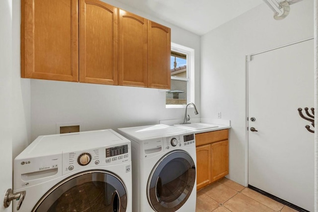 laundry area featuring light tile patterned flooring, cabinets, sink, and washer and dryer