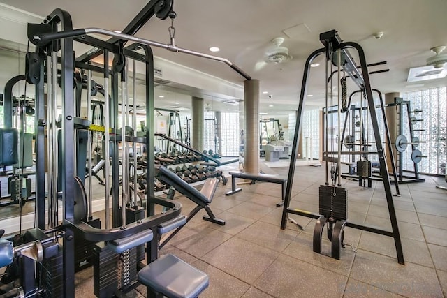 gym with ceiling fan and crown molding