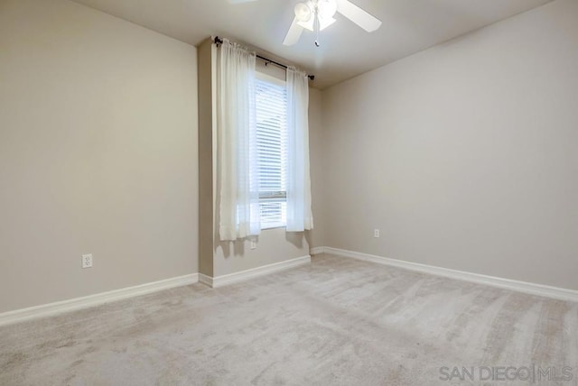 spare room featuring ceiling fan and light colored carpet