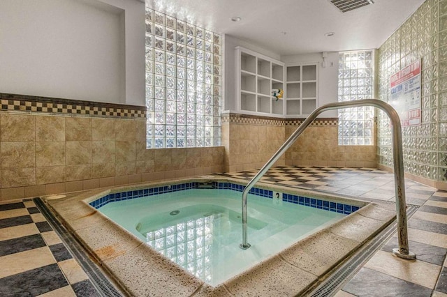 view of swimming pool with an indoor hot tub