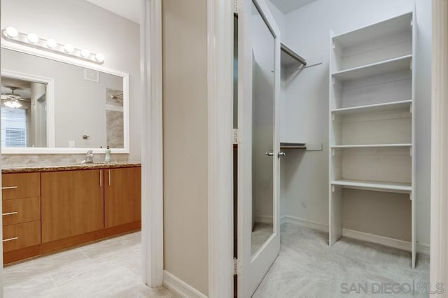 bathroom featuring ceiling fan and vanity