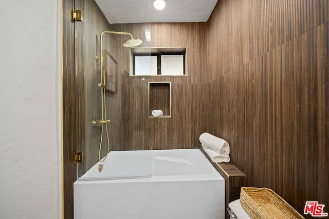 bathroom with toilet and tiled shower / bath combo