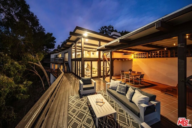 deck at dusk featuring an outdoor living space