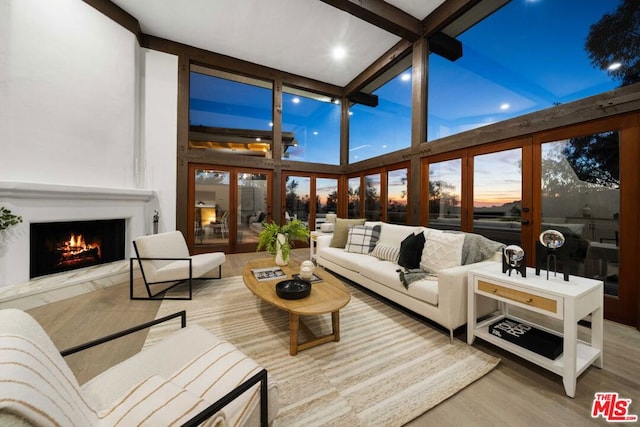 sunroom / solarium featuring a fireplace and beamed ceiling