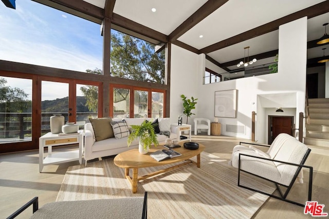 living room featuring a high ceiling, a wealth of natural light, beam ceiling, and french doors