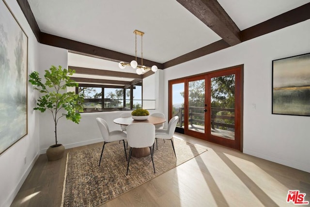 dining room featuring light hardwood / wood-style floors, beam ceiling, and french doors