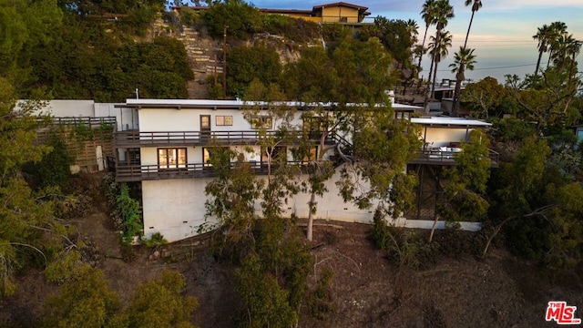 back house at dusk with a balcony