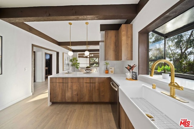 kitchen with hanging light fixtures, a healthy amount of sunlight, dishwasher, and sink