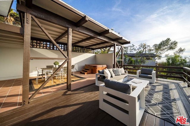 wooden terrace with a hot tub and an outdoor living space with a fire pit