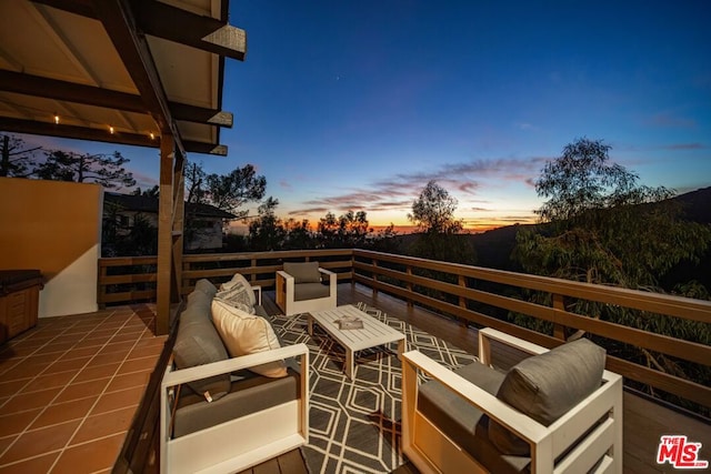 balcony at dusk featuring an outdoor living space