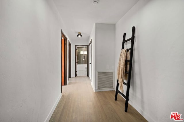 hallway with light hardwood / wood-style floors