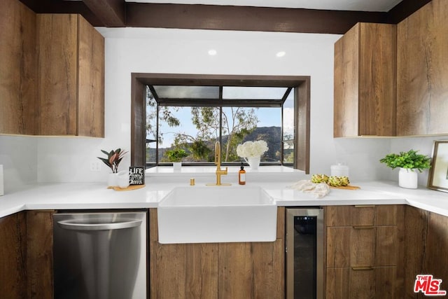 kitchen with stainless steel dishwasher, sink, and beverage cooler