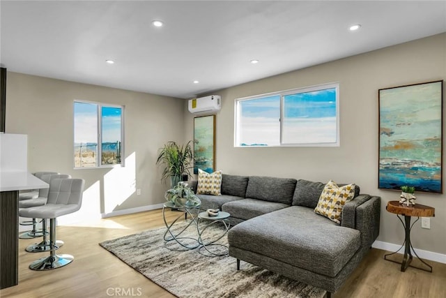 living room with plenty of natural light, light hardwood / wood-style floors, and a wall mounted AC