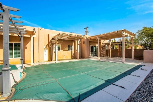 back of house featuring a pergola and a covered pool