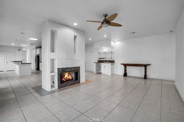 unfurnished living room with ceiling fan, light tile patterned flooring, and a multi sided fireplace