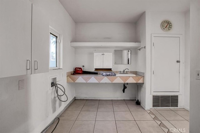 kitchen featuring light tile patterned floors and white cabinets