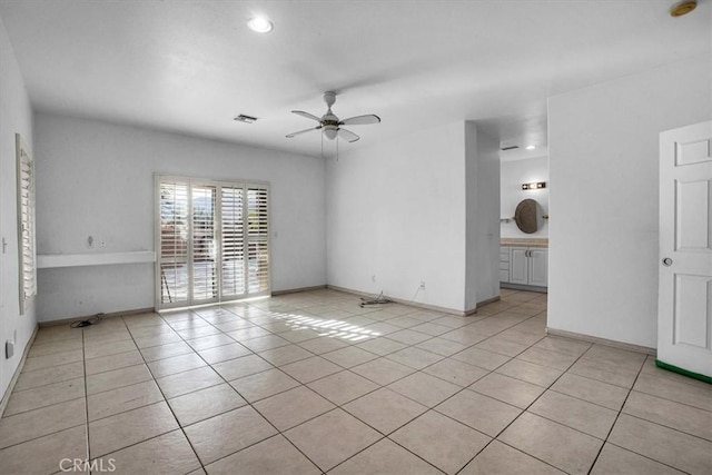 tiled spare room with ceiling fan