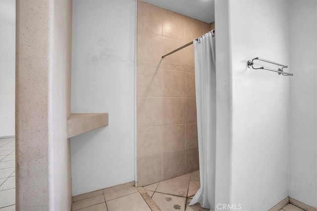 bathroom with curtained shower and tile patterned flooring