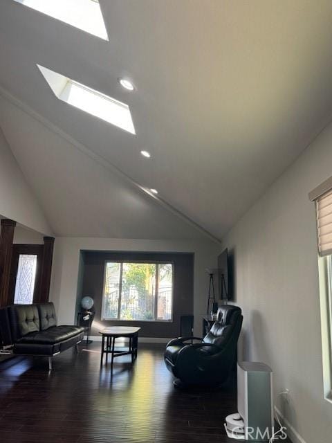 living room featuring lofted ceiling with skylight, recessed lighting, baseboards, and wood finished floors