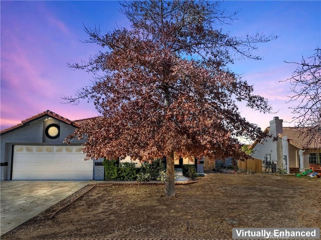 view of property hidden behind natural elements featuring a garage