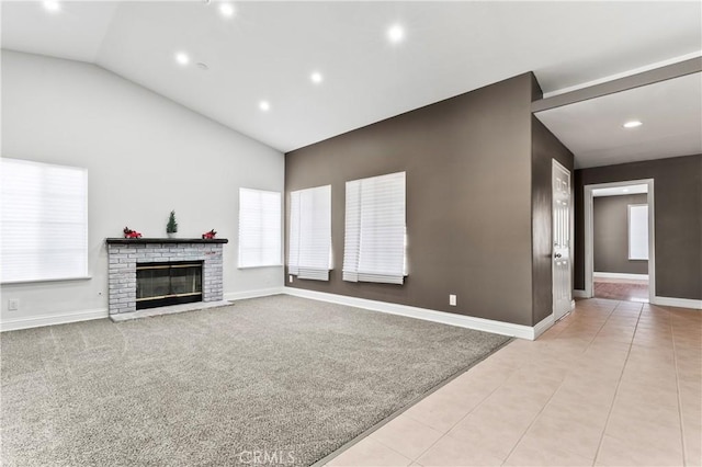 unfurnished living room featuring a brick fireplace, light tile patterned floors, and vaulted ceiling