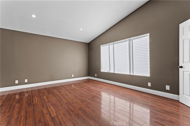 spare room with lofted ceiling and wood-type flooring