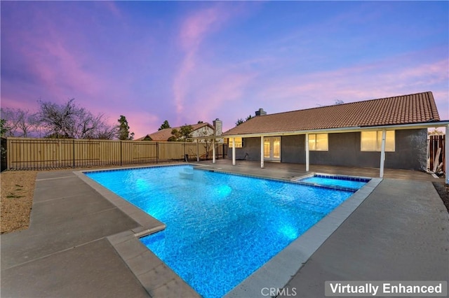 pool at dusk featuring a patio area