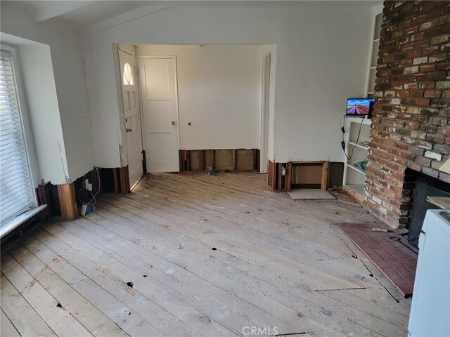 unfurnished living room featuring light wood-type flooring and plenty of natural light