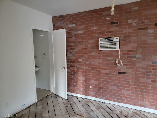 spare room with brick wall and a wall mounted AC