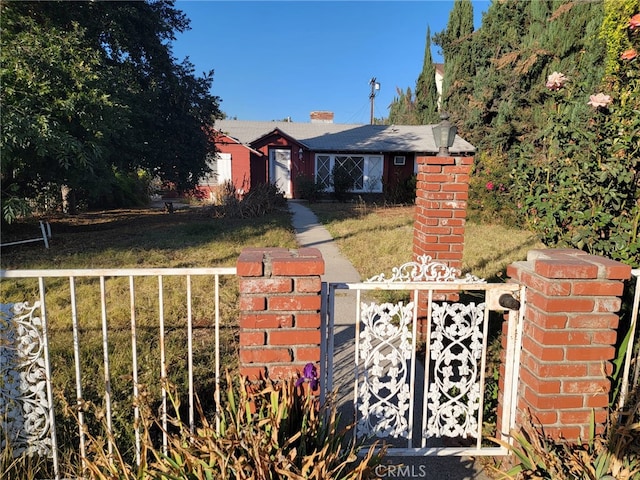 view of gate with a lawn