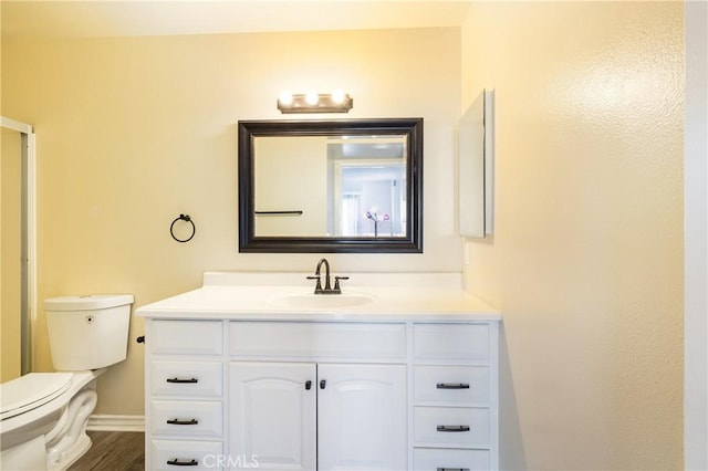 bathroom featuring toilet, vanity, and hardwood / wood-style floors