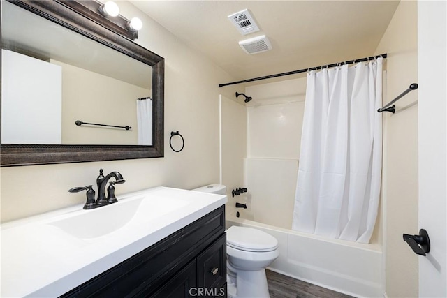 full bathroom featuring hardwood / wood-style floors, toilet, vanity, and shower / tub combo