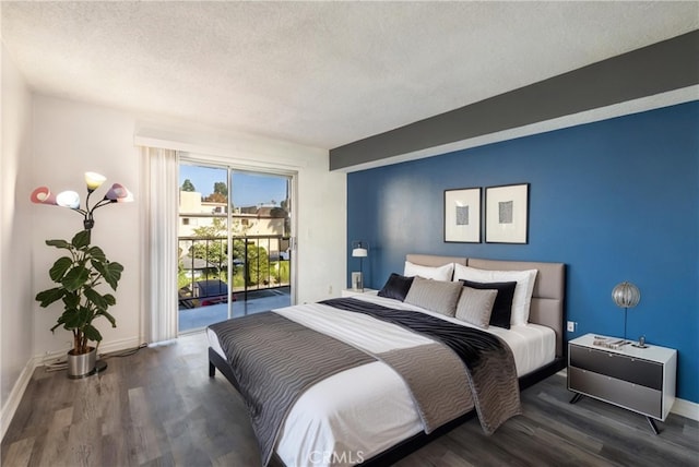 bedroom with access to exterior, dark hardwood / wood-style flooring, and a textured ceiling