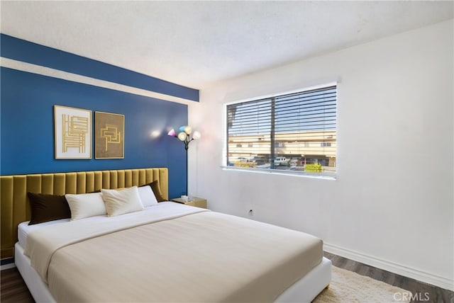 bedroom with a textured ceiling and dark hardwood / wood-style floors