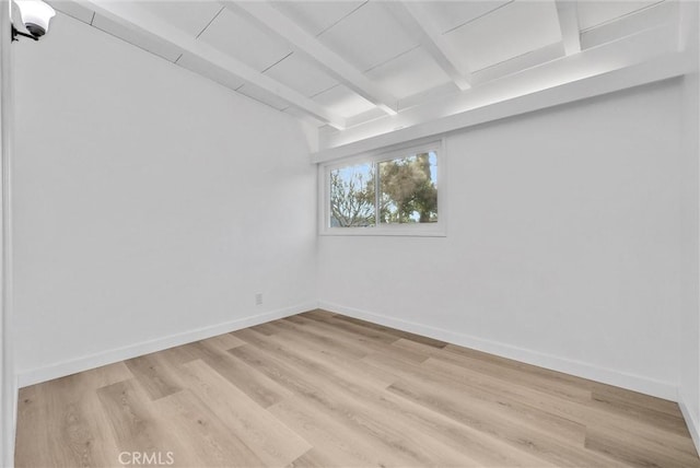 unfurnished room with light wood-type flooring and beam ceiling