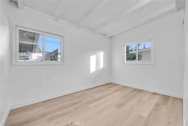 empty room featuring lofted ceiling with beams, wood ceiling, and light hardwood / wood-style flooring