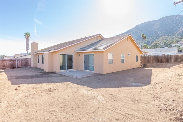 back of property featuring a mountain view and cooling unit