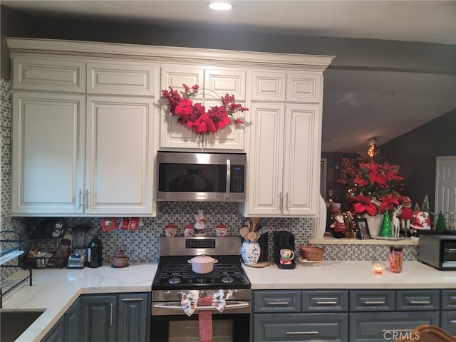 2214 Mark St, Santa Ana, CA 92703 - kitchen with light stone counters, appliances with stainless steel finishes, gray cabinets, and decorative backsplash