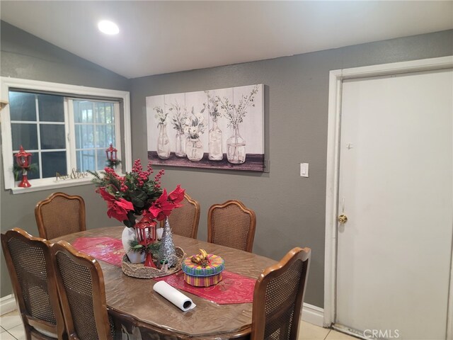 tiled dining area featuring lofted ceiling