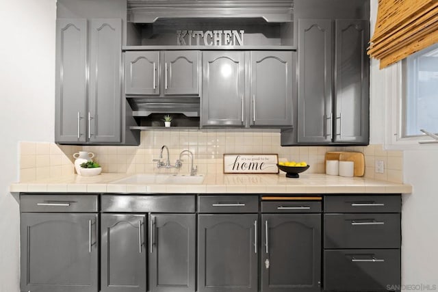 kitchen featuring decorative backsplash, sink, and gray cabinetry