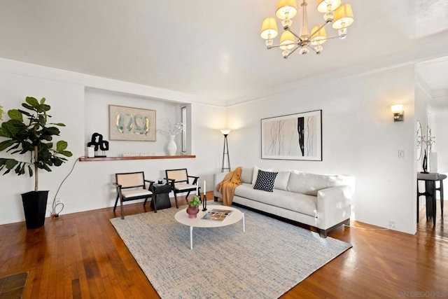 living room featuring a notable chandelier, crown molding, and hardwood / wood-style flooring